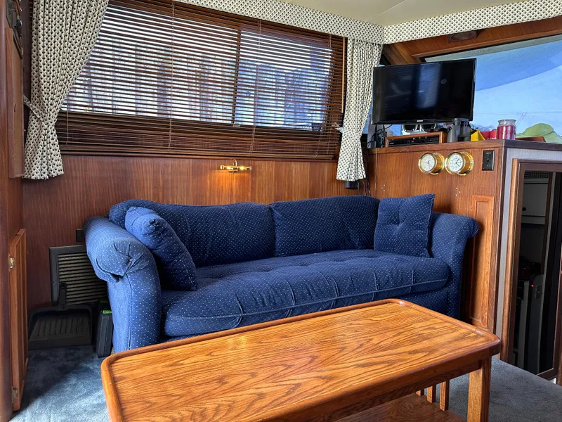 Slide: The Image of Interior of 1985 Hatteras 36 Convertible with blue sofa and wooden table. - 14