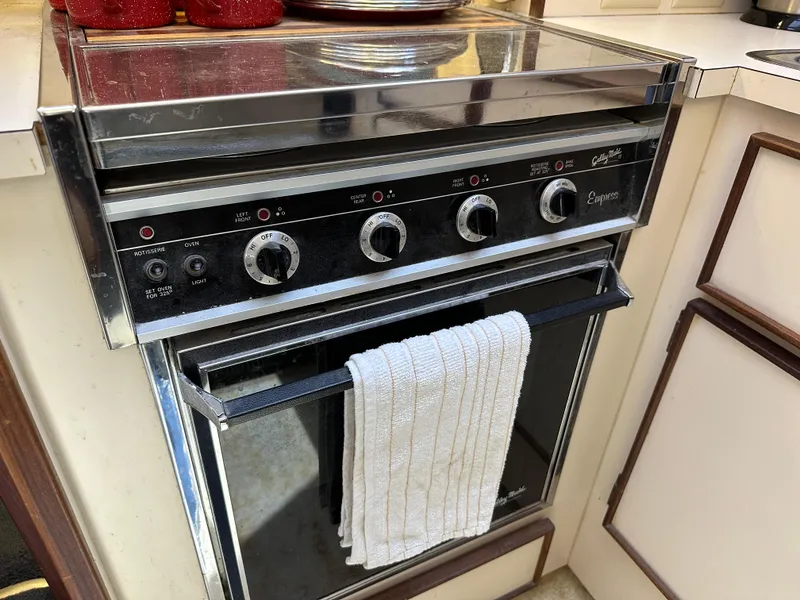 Slide: The Image of 1985 Hatteras 36 Convertible kitchen oven with a white towel hanging. - 18