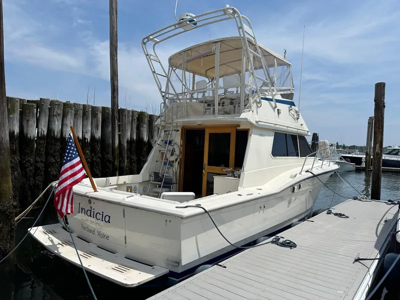 Slide: The Image of 1985 Hatteras 36 Convertible docked, rear view with American flag. - 2