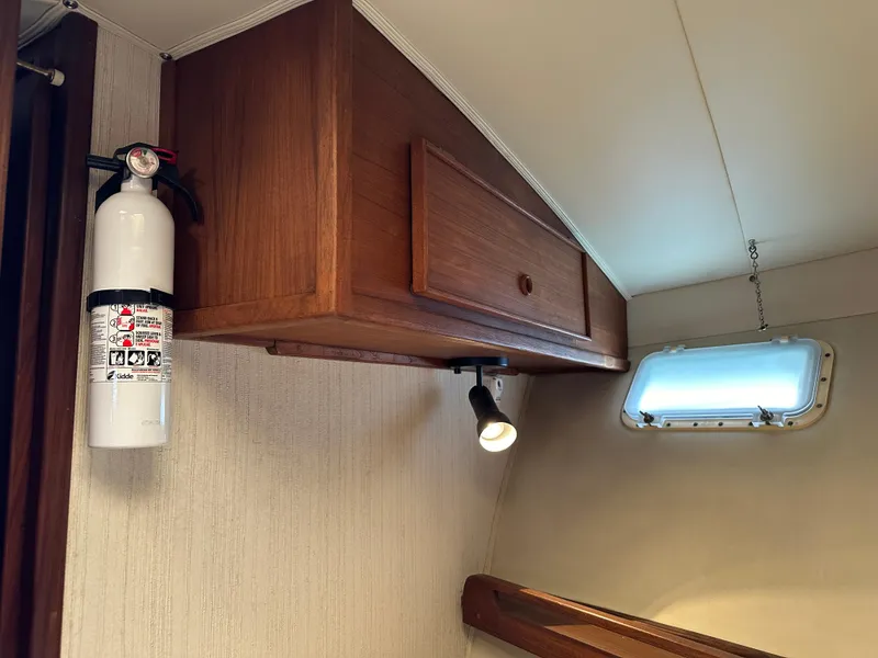 Slide: The Image of Fire extinguisher and wooden cabinet in 1985 Hatteras 36 Convertible boat interior. - 26