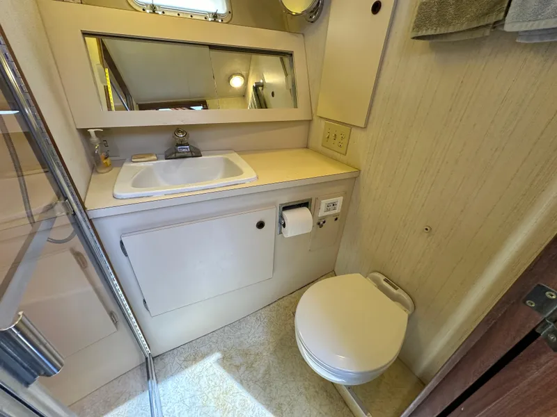 Slide: The Image of 1985 Hatteras 36 Convertible bathroom with sink, mirror, and toilet. - 28