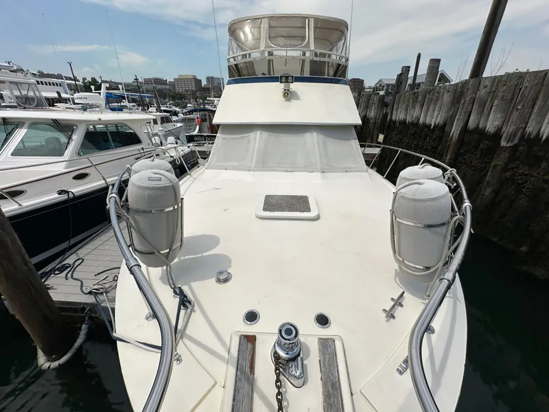 Slide: The Image of 1985 Hatteras 36 Convertible yacht docked at a marina, view of the bow. - 37