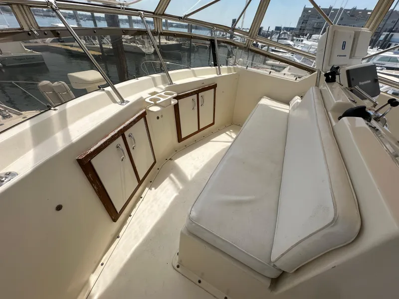 Slide: The Image of 1985 Hatteras 36 Convertible boat interior with cushioned seating and storage cabinets. - 41