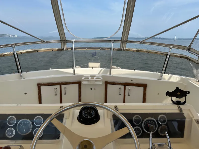 Slide: The Image of 1985 Hatteras 36 Convertible yacht helm with ocean view and clear skies. - 49