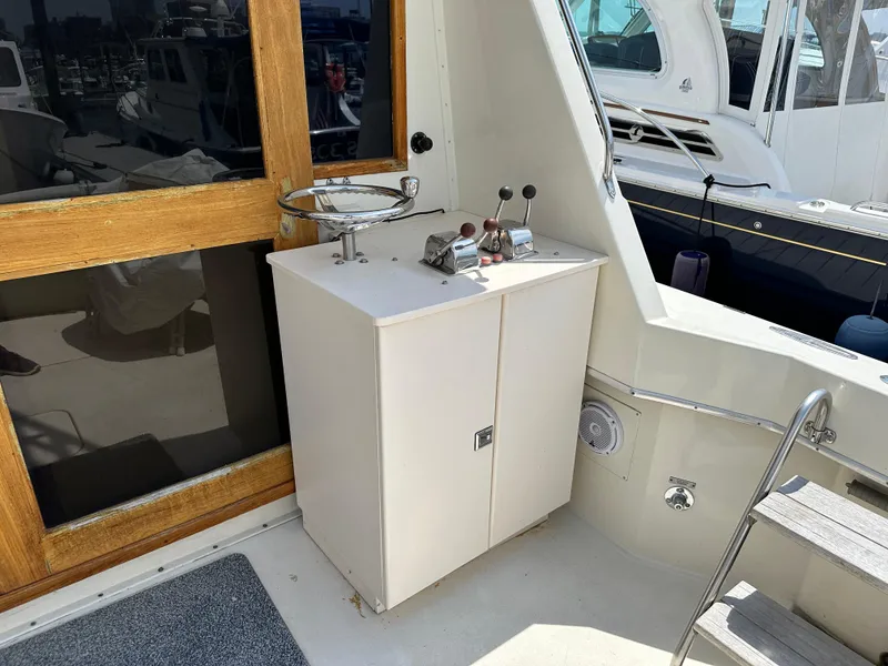 Slide: The Image of 1985 Hatteras 36 Convertible boat interior with control panel and wooden door. - 5