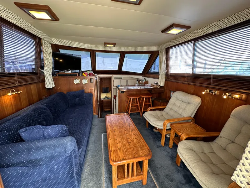 Slide: The Image of Interior of 1985 Hatteras 36 Convertible yacht with cozy seating and wooden accents. - 7
