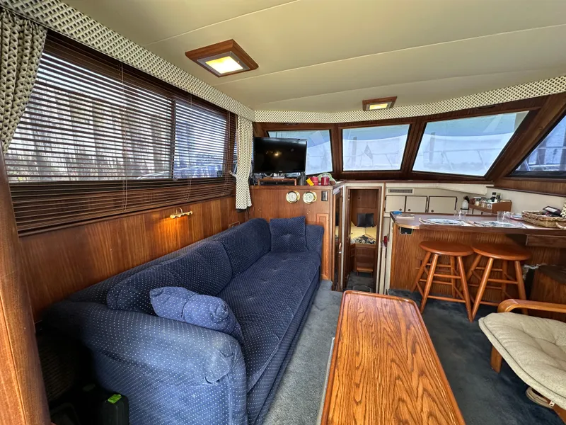 Slide: The Image of Interior of 1985 Hatteras 36 Convertible yacht with blue sofa and wooden furnishings. - 8