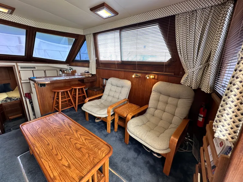 Slide: The Image of Interior of 1985 Hatteras 36 Convertible with wooden furniture and cushioned chairs. - 9