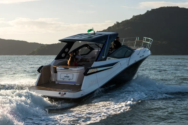 Slide: The Image of 2025 NHD 325 Open Deck boat cruising on the water with passengers. - 2