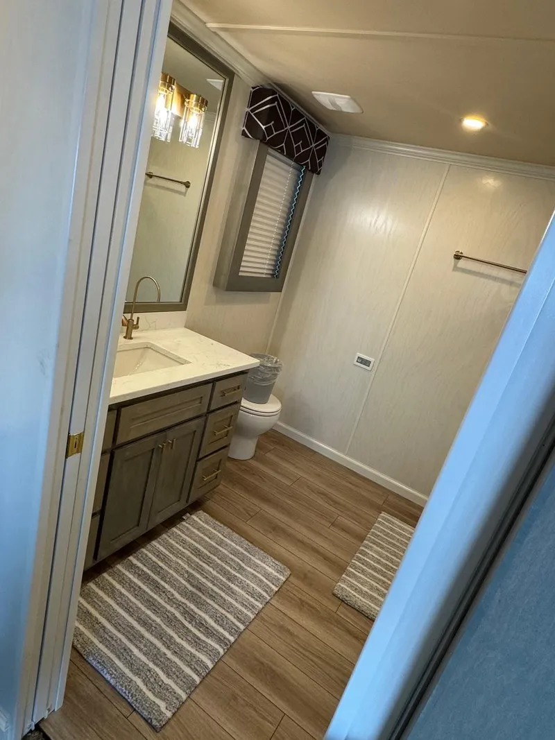 Slide: The Image of Modern bathroom in 2024 Sumerset Limitless Share 10 houseboat with wood flooring and elegant fixtures. - 15