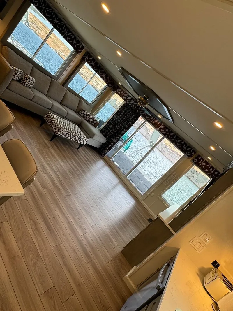 Slide: The Image of Spacious interior of 2024 Sumerset Limitless Share 10 houseboat with modern furnishings and large windows. - 6