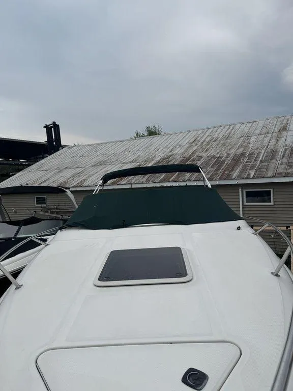 Slide: The Image of 1999 Sea Ray Weekender 240 boat with green cover docked near a building. - 4