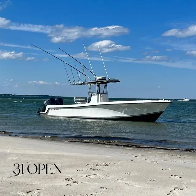 Slide: The Image of 2003 Contender 31 Open boat anchored near sandy beach on a sunny day. - 1