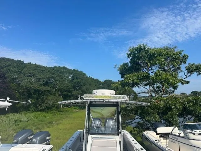 Slide: The Image of 2003 Contender 31 Open boat with twin Yamaha engines, docked near lush greenery. - 14