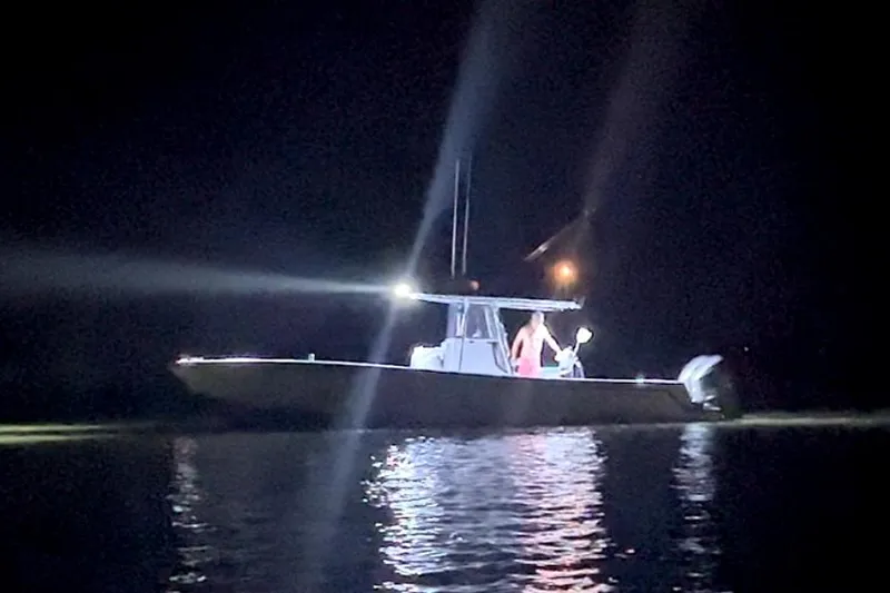 Slide: The Image of 2003 Contender 31 Open boat illuminated at night on the water. - 17