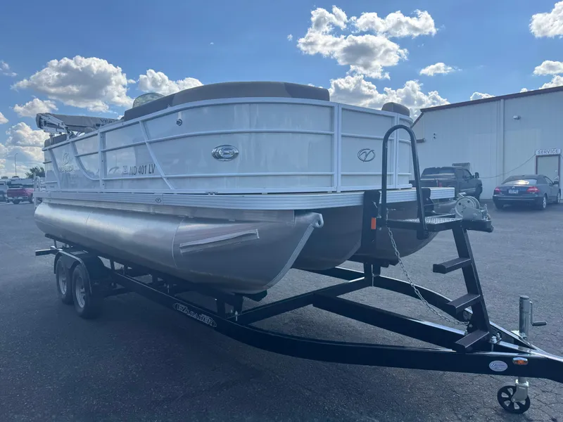 Slide: The Image of 2023 Veranda Relax VR20RC pontoon boat on trailer under a bright blue sky. - 2