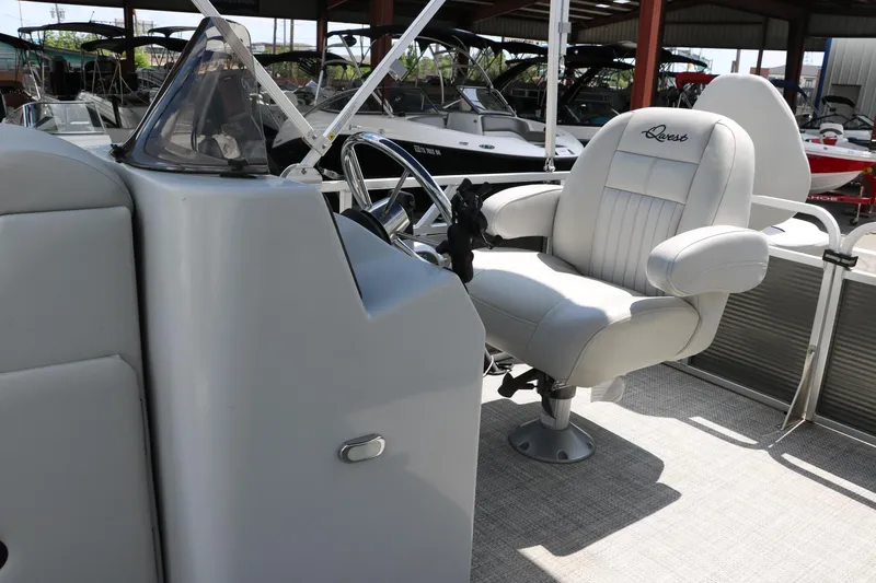 Slide: The Image of Captain's seat and console of a 2020 Qwest 818 EDGE boat in a marina. - 32