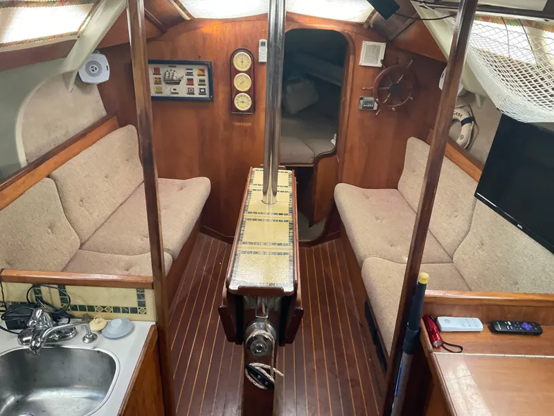 Slide: The Image of Interior of 1983 Jeanneau Attalia sailboat with cozy seating and wooden finishes. - 11
