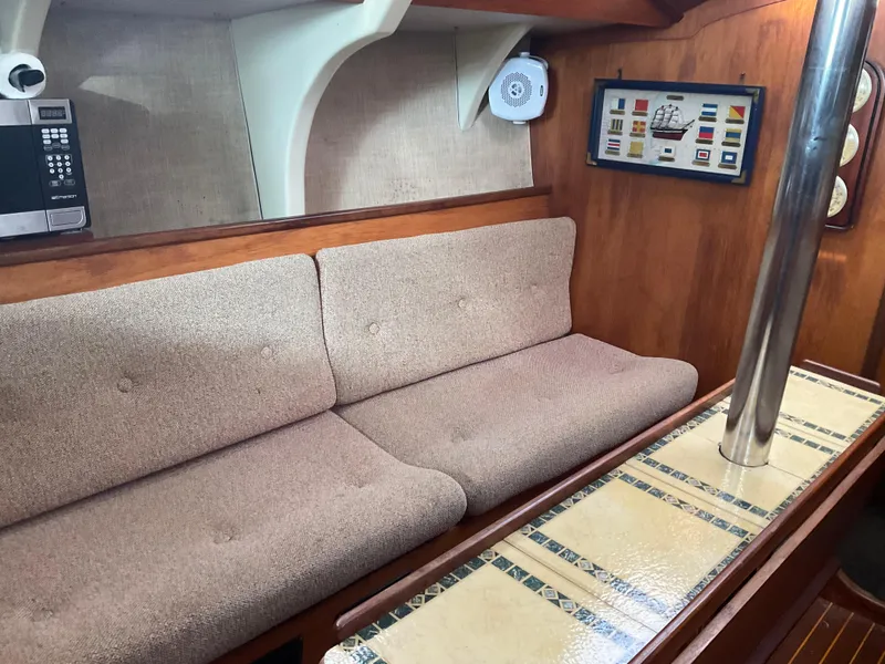 Slide: The Image of Interior of 1983 Jeanneau Attalia sailboat with cozy seating and nautical decor. - 14