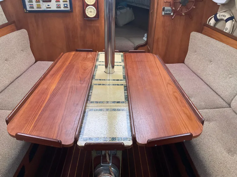 Slide: The Image of Interior of 1983 Jeanneau Attalia sailboat with wooden table and cushioned seating. - 17