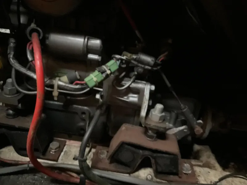 Slide: The Image of Engine components of a 1983 Jeanneau Attalia sailboat, featuring wiring and mechanical parts. - 23