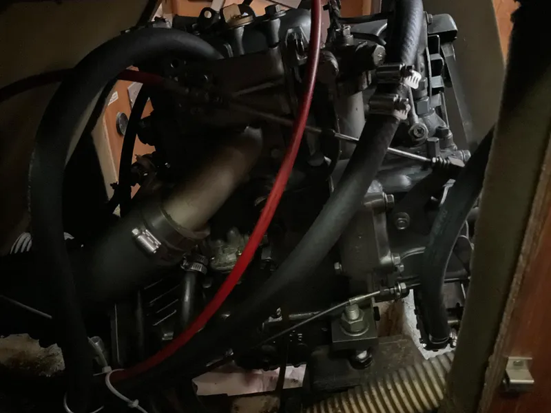 Slide: The Image of Engine compartment of a 1983 Jeanneau Attalia sailboat, showing hoses and mechanical components. - 26