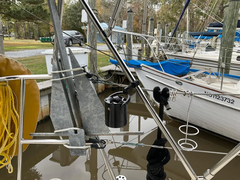 Slide: The Image of 1983 Jeanneau Attalia sailboat docked, featuring anchor and mooring lines. - 37
