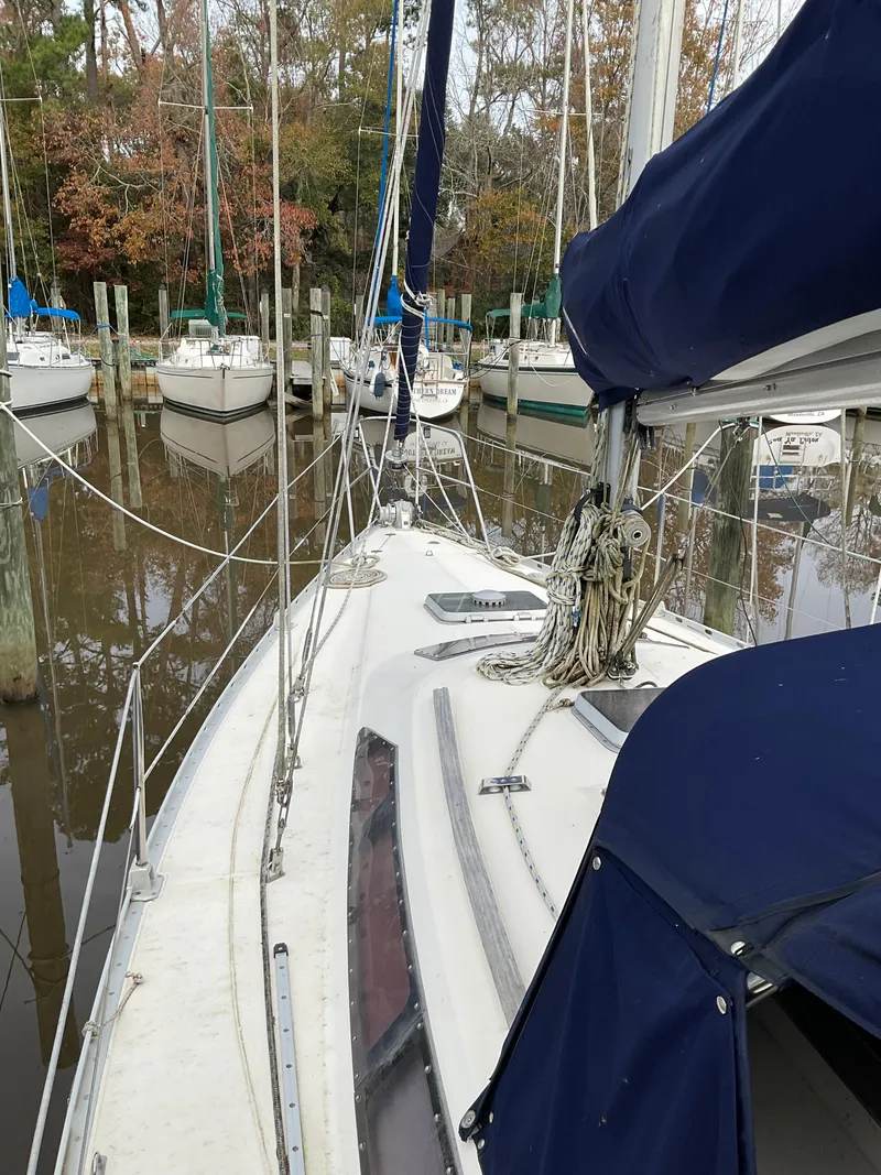 Slide: The Image of 1983 Jeanneau Attalia sailboat docked in a marina, surrounded by other boats. - 41