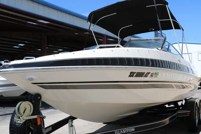 Slide: The Image of 2008 Glastron GT225 boat with black canopy on trailer in storage facility. - 11