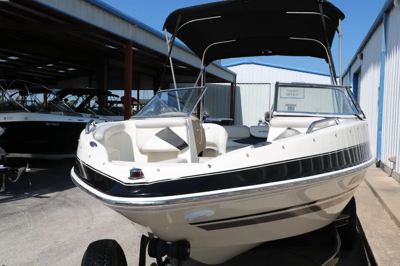 Slide: The Image of 2008 Glastron GT225 boat with black canopy in storage facility. - 13