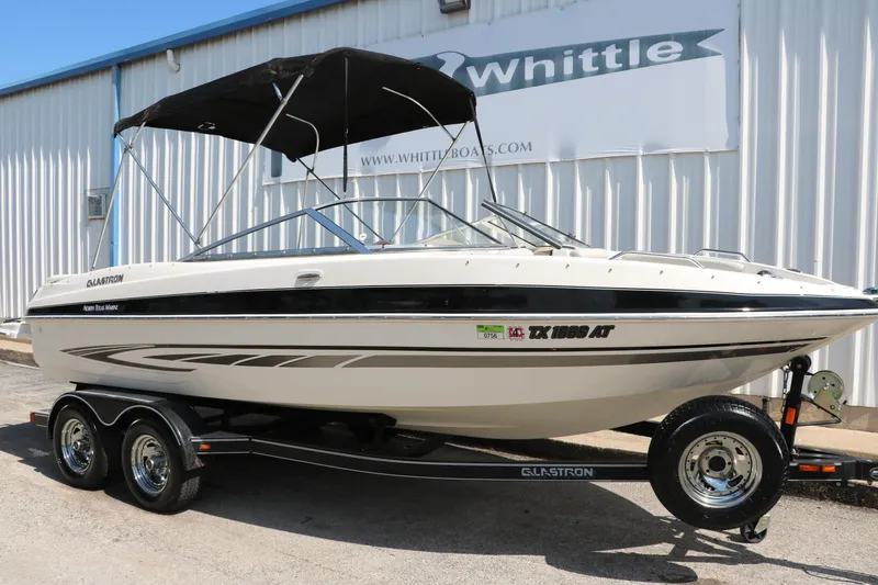 Slide: The Image of 2008 Glastron GT225 boat on trailer with black canopy, parked outside Whittle Boats. - 16