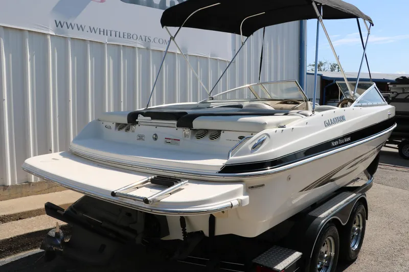 Slide: The Image of 2008 Glastron GT225 boat on trailer with bimini top, parked outside Whittle Boats. - 4