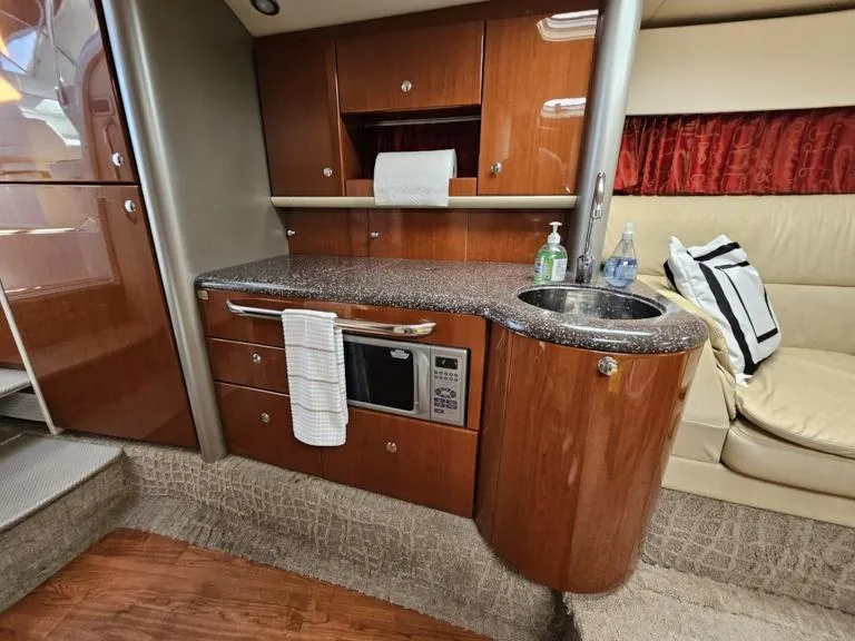 Slide: The Image of 2007 Formula 400 Super Sport yacht interior kitchen with microwave, sink, and wooden cabinetry. - 24