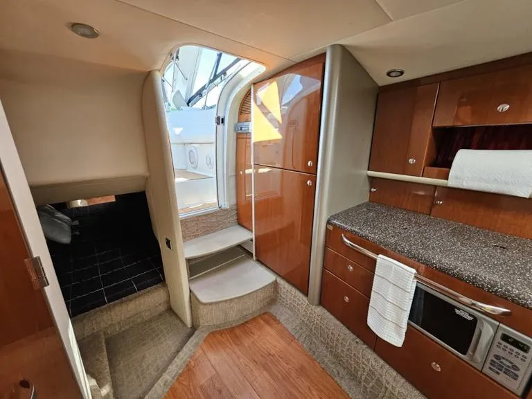 Slide: The Image of Interior of a 2007 Formula 400 Super Sport yacht with modern kitchen and wooden cabinetry. - 26