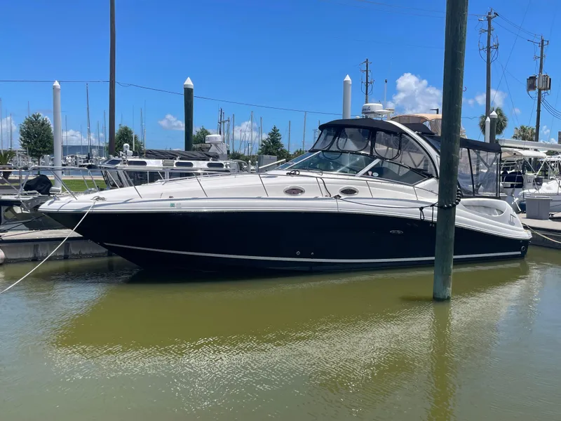 Slide: The Image of 2007 Sea Ray 340 Sundancer yacht docked in a marina under clear blue skies. - 2