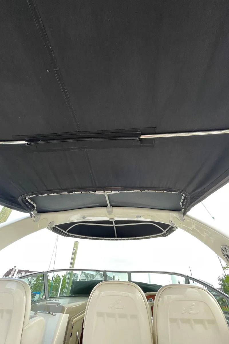 Slide: The Image of 2007 Sea Ray 340 Sundancer boat interior with black canopy and white seating. - 24