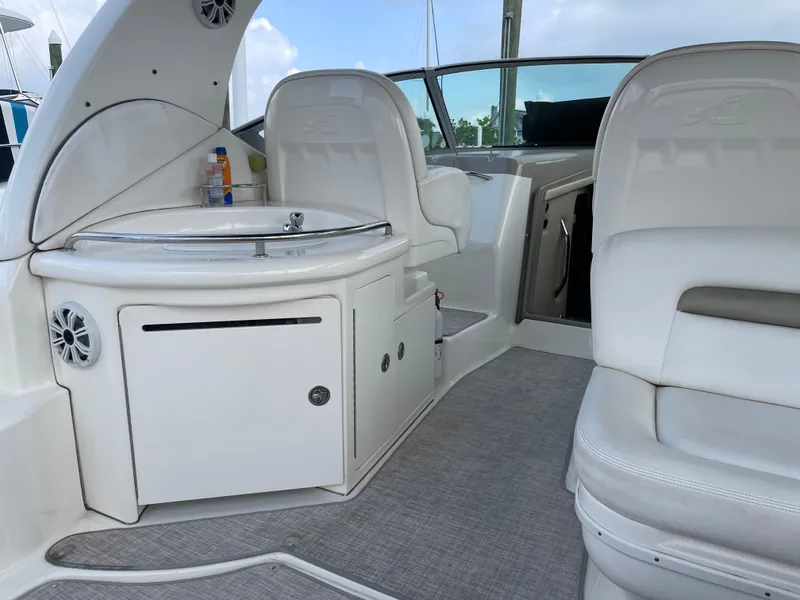 Slide: The Image of 2007 Sea Ray 340 Sundancer interior with white seating and compact kitchenette. - 30