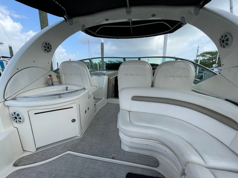 Slide: The Image of 2007 Sea Ray 340 Sundancer interior with white seating and helm, under a black canopy. - 32