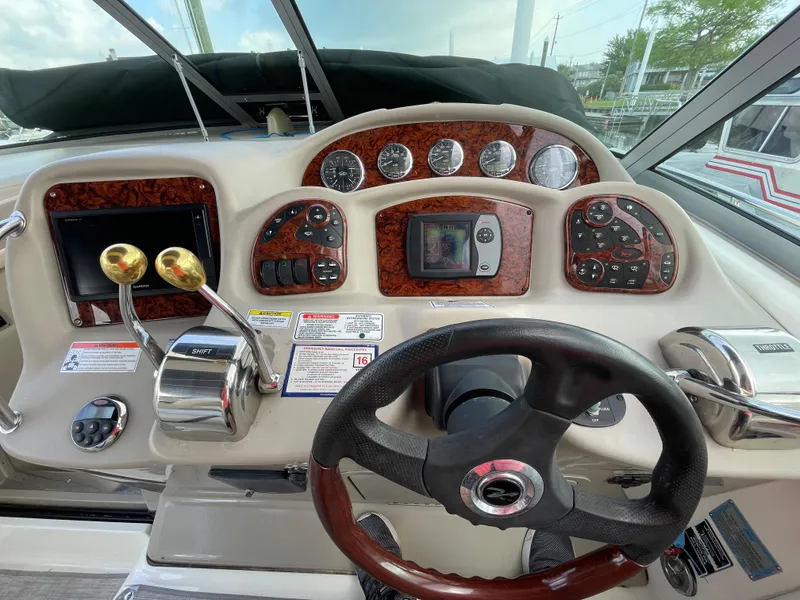Slide: The Image of 2007 Sea Ray 340 Sundancer helm with steering wheel, gauges, and control panels. - 37