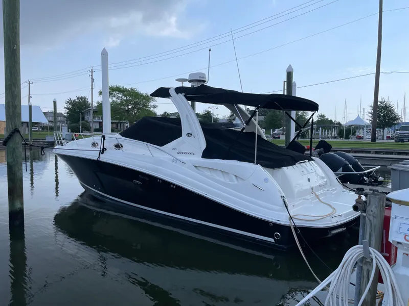 Slide: The Image of 2007 Sea Ray 340 Sundancer boat docked at marina, featuring sleek black and white design. - 6