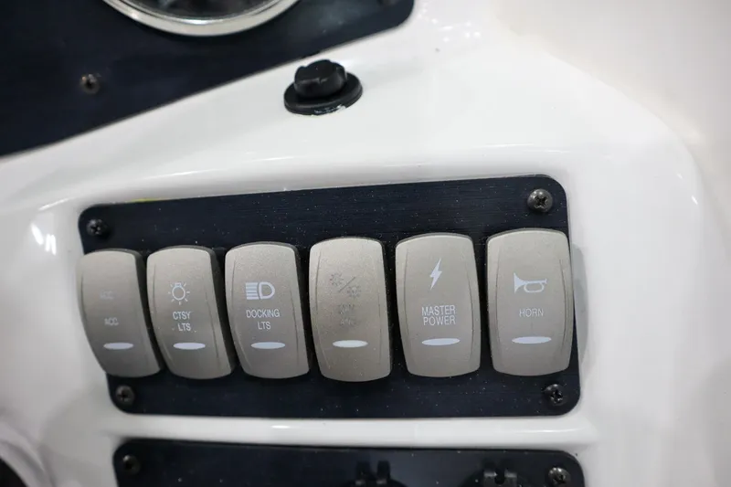 Slide: The Image of Control panel switches on a 2024 Hurricane SunDeck 2486 OB boat. - 15