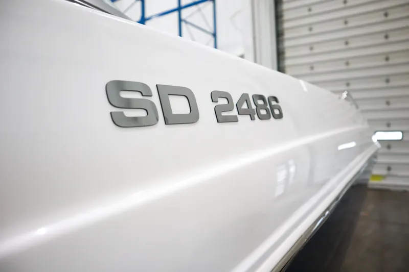 Slide: The Image of Close-up of 2024 Hurricane SunDeck 2486 OB boat model name on hull. - 24