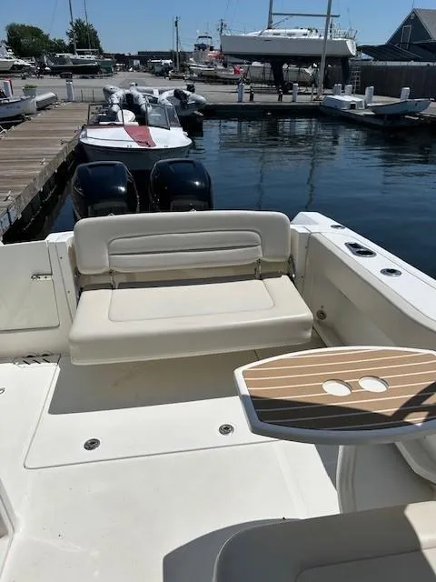 Slide: The Image of 2018 Boston Whaler 270 Vantage at a marina, featuring a spacious seating area. - 14