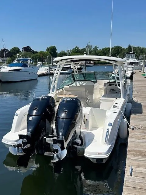 Slide: The Image of 2018 Boston Whaler 270 Vantage docked, featuring dual outboard engines. - 16