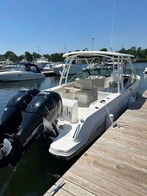 Slide: The Image of 2018 Boston Whaler 270 Vantage docked at a marina with twin outboard engines. - 4