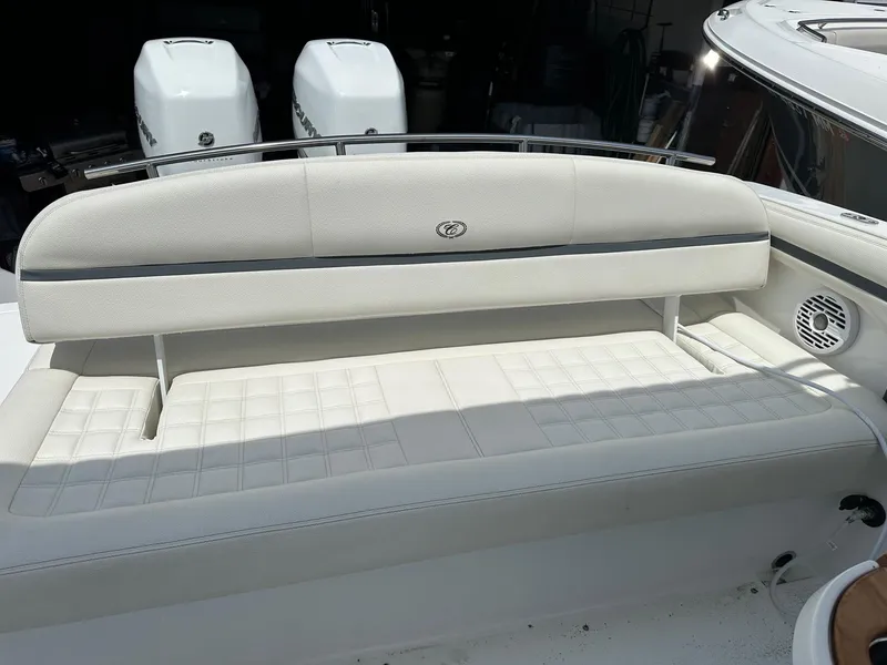 Slide: The Image of 2021 Cobalt 30SC Outboard boat with white cushioned seating and twin outboard engines. - 12