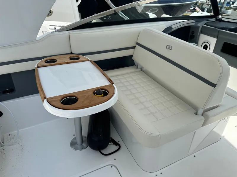 Slide: The Image of 2021 Cobalt 30SC Outboard boat interior with white seating and wooden table. - 13