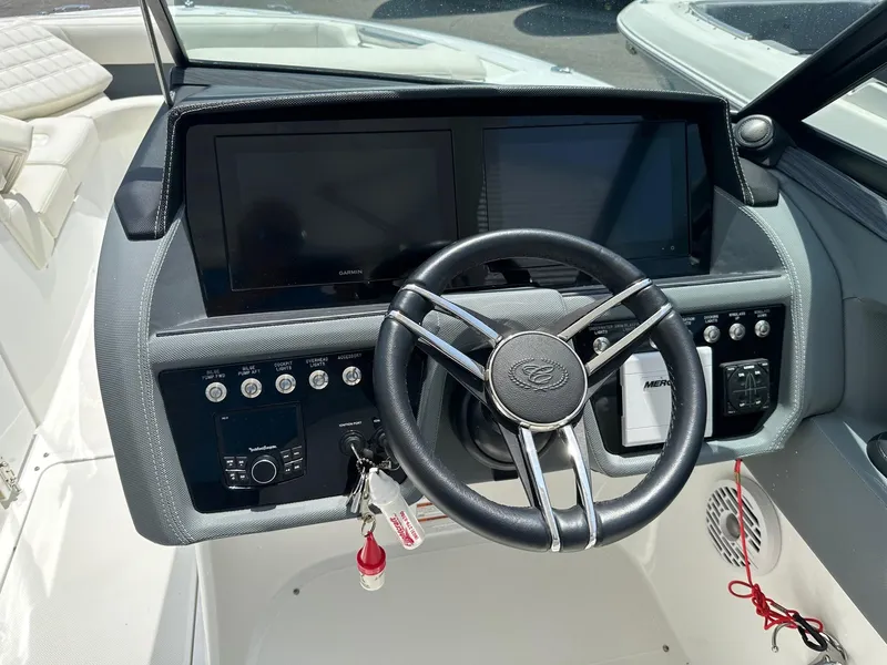 Slide: The Image of 2021 Cobalt 30SC Outboard boat dashboard with steering wheel and dual display screens. - 15