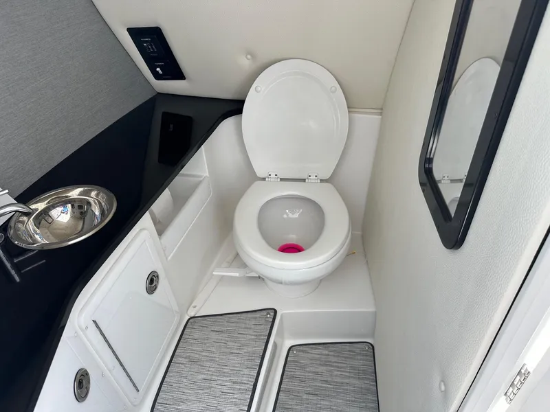 Slide: The Image of 2021 Cobalt 30SC Outboard boat bathroom with toilet, sink, and mirror. - 19