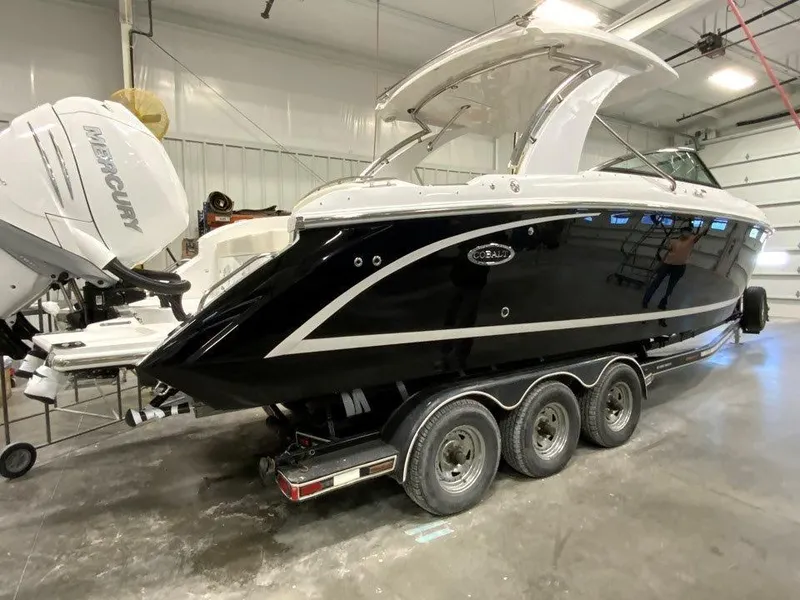 Slide: The Image of 2021 Cobalt 30SC Outboard boat on a triple-axle trailer in a storage facility. - 2